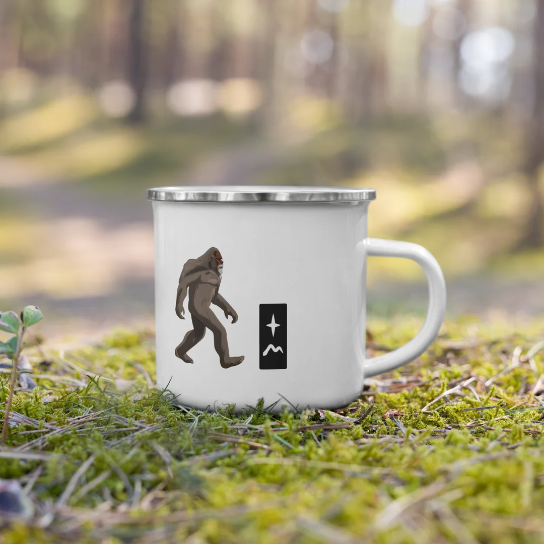 The Lift Your Eyes camp mug on the moss, out on the trail.