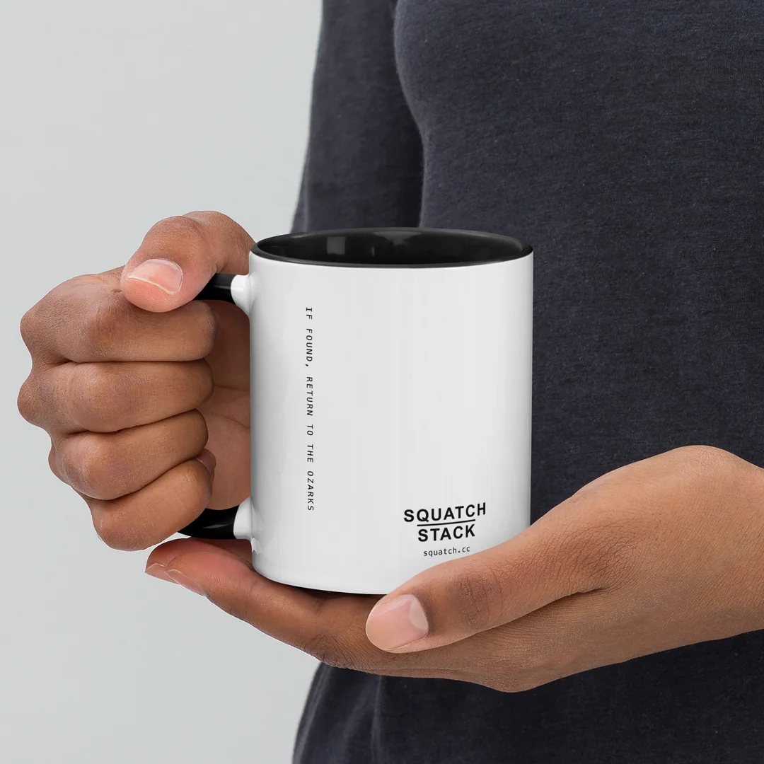 The Founder mug, held by the handle.